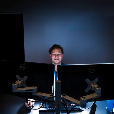 Studiekiezer achter meerdere beeldschermen bezig met het beveiligen van digitale informatie
