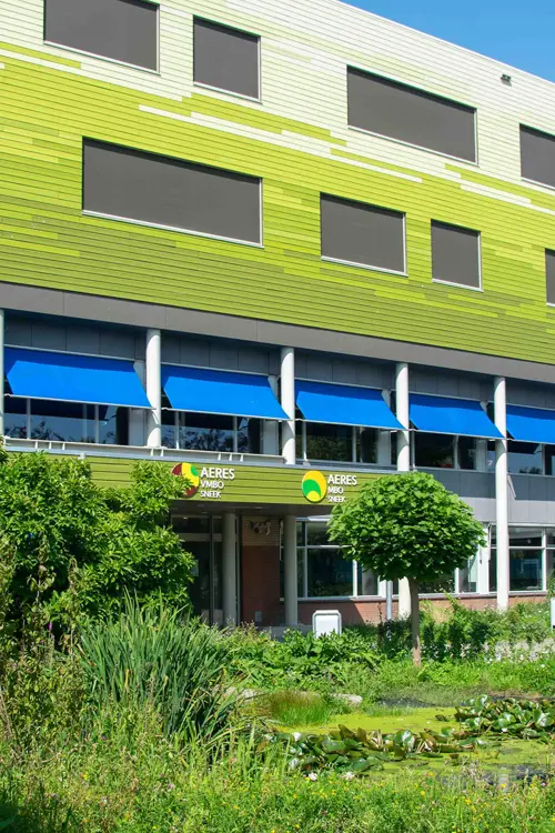 Hoofdingang van Aeres MBO Sneek met gebouw en groene tuin rondom, gericht op jongeren die mbo-opleidingen zoeken