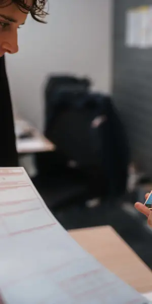 Medewerker gebruikt smartphone om kantoorwerk te ondersteunen en documenten te beheren