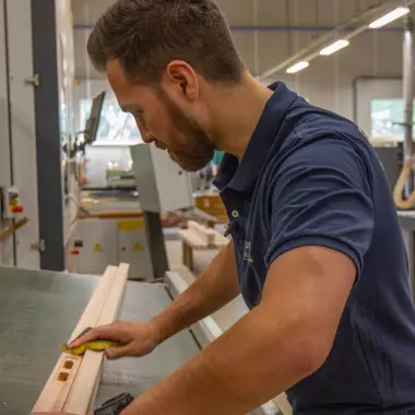 Student werkt nauwkeurig met houtbewerking in een leerwerkplaats gericht op meubels en constructies