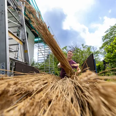 Vakman verwerkt natuurlijke bouwmaterialen voor dakbedekking bij een project gericht op gespecialiseerde aanneming
