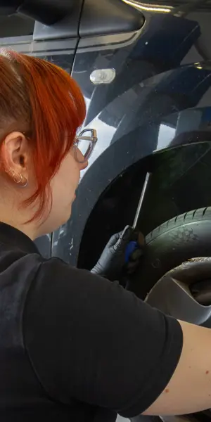 Technisch specialist controleert bandenspanning van voertuig met meetapparatuur in werkplaats