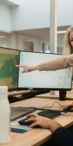 Studenten werken samen aan een computer met educatieve software in een kantooromgeving