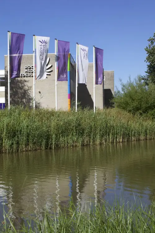 ROC Midden Nederland gebouw aan Harmonielaan 2 met vlaggen en waterpartij op de voorgrond