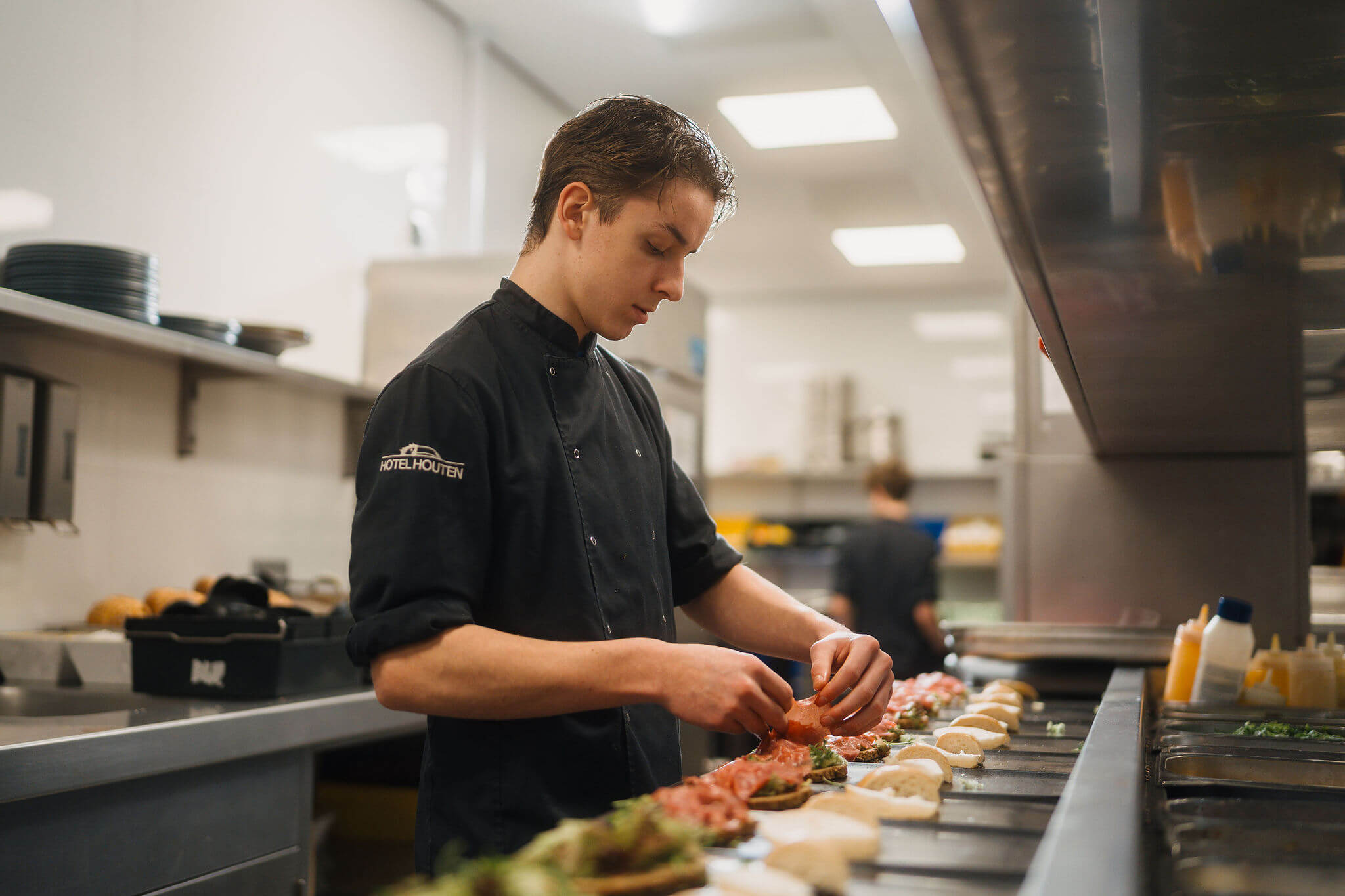 Kok bereidt zorgvuldig diverse gerechten in een professionele keuken als onderdeel van het horecateam.