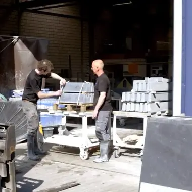 Twee vakbekwame bouwprofessionals laden bouwmaterialen in een werkplaats voor gespecialiseerde aanneming.