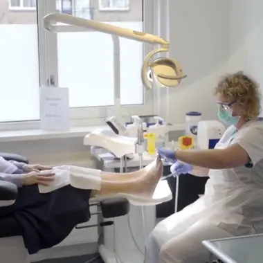 Zorgprofessional verzorgt voeten van cliënt in een praktijk voor uiterlijke verzorging en advies over beauty.