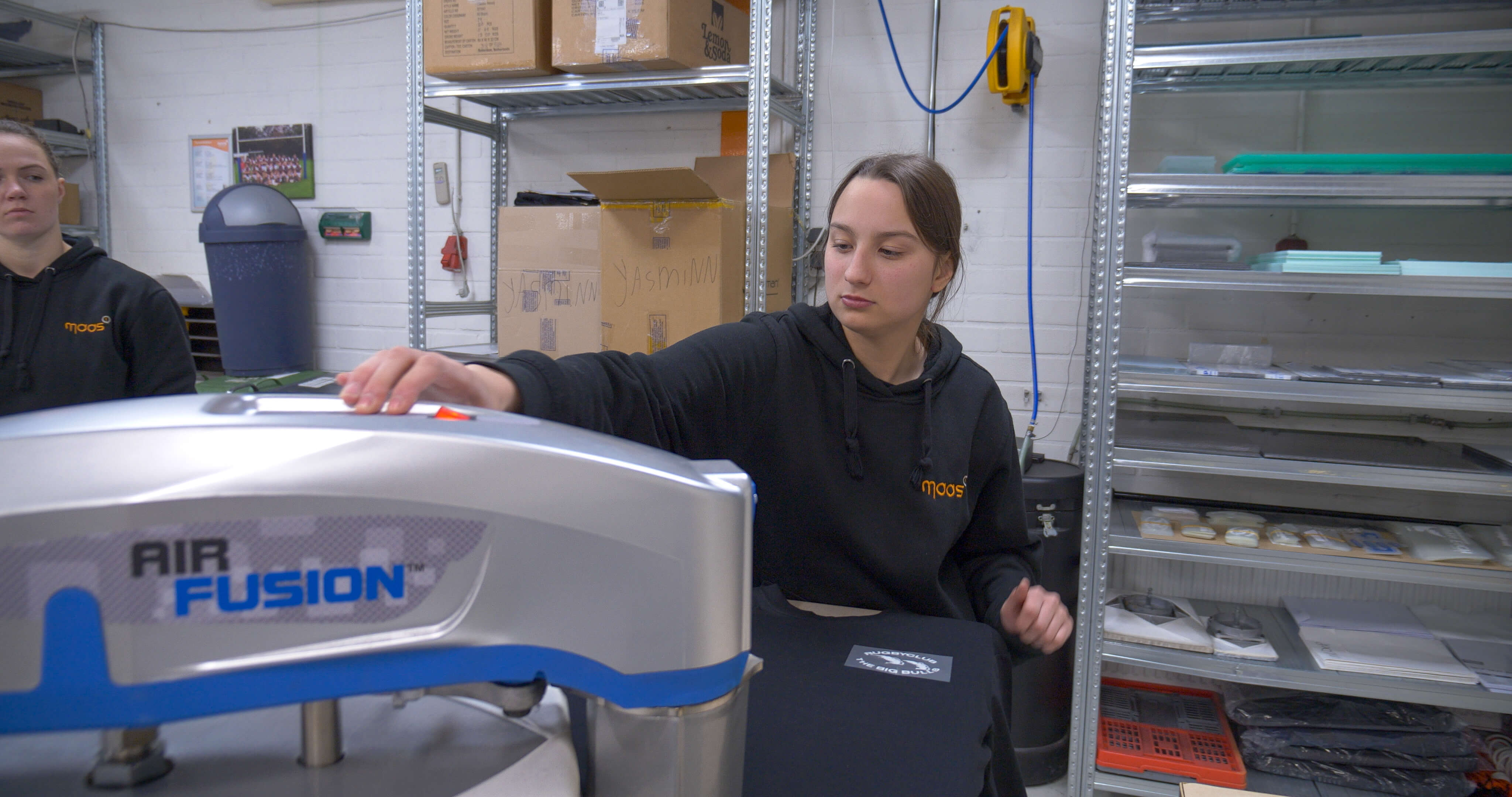 Student werkt met machine voor materiaalbewerking in een technische praktijkruimte.