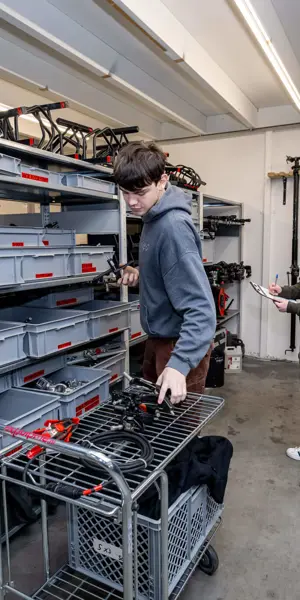 Leerlingen verzamelen en controleren filmmateriaal in een opslagruimte tijdens hun opleiding AV-specialist.