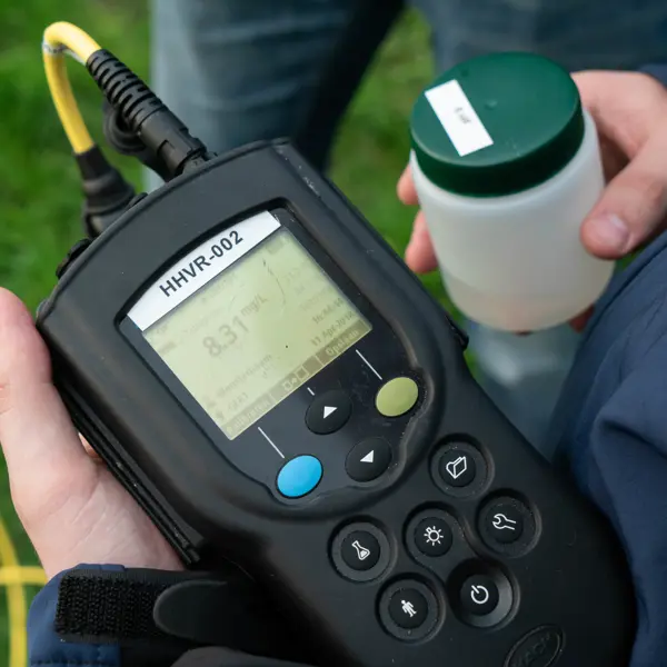 Adviseur leefomgeving meet milieugegevens met een draagbaar meetinstrument voor onderzoek en controle.