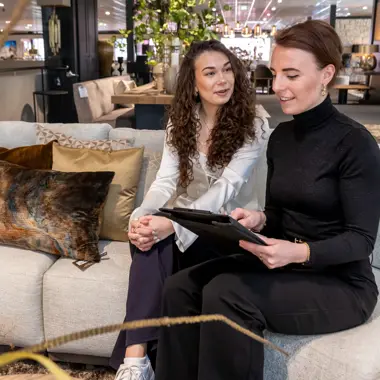 Twee studiekiezers bespreken retailopleidingen en winkelfuncties in een ontspannen setting.