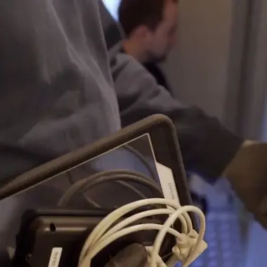 Technisch medewerker bekijkt en bedient een tablet voor het installeren van elektrotechnische systemen in een gebouw