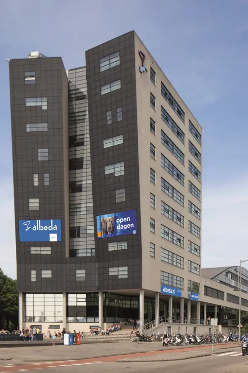Gebouw van Albeda aan de Rosestraat met reclameborden en fietsenrekken voor de hoofdingang