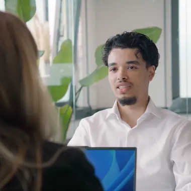 Consulent commerciële arbeidsbemiddeling voert gesprek met een bezoeker in een moderne kantooromgeving