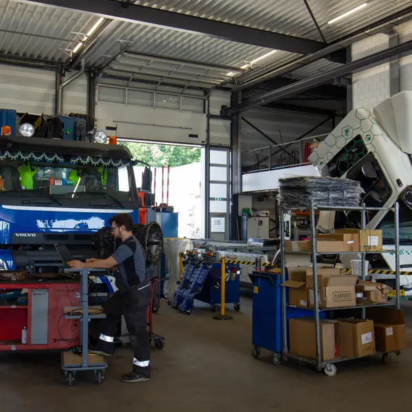 Technisch specialist werkt aan storingen bij truck in werkplaats voor voertuigen en mobiele werktuigen