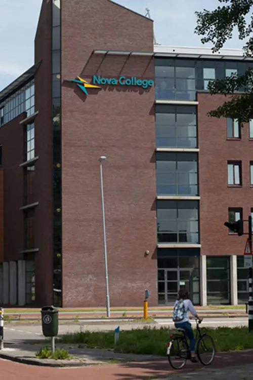 Fietsers passeren het gebouw van Nova College aan de Zijlweg in Haarlem, een mbo-instelling