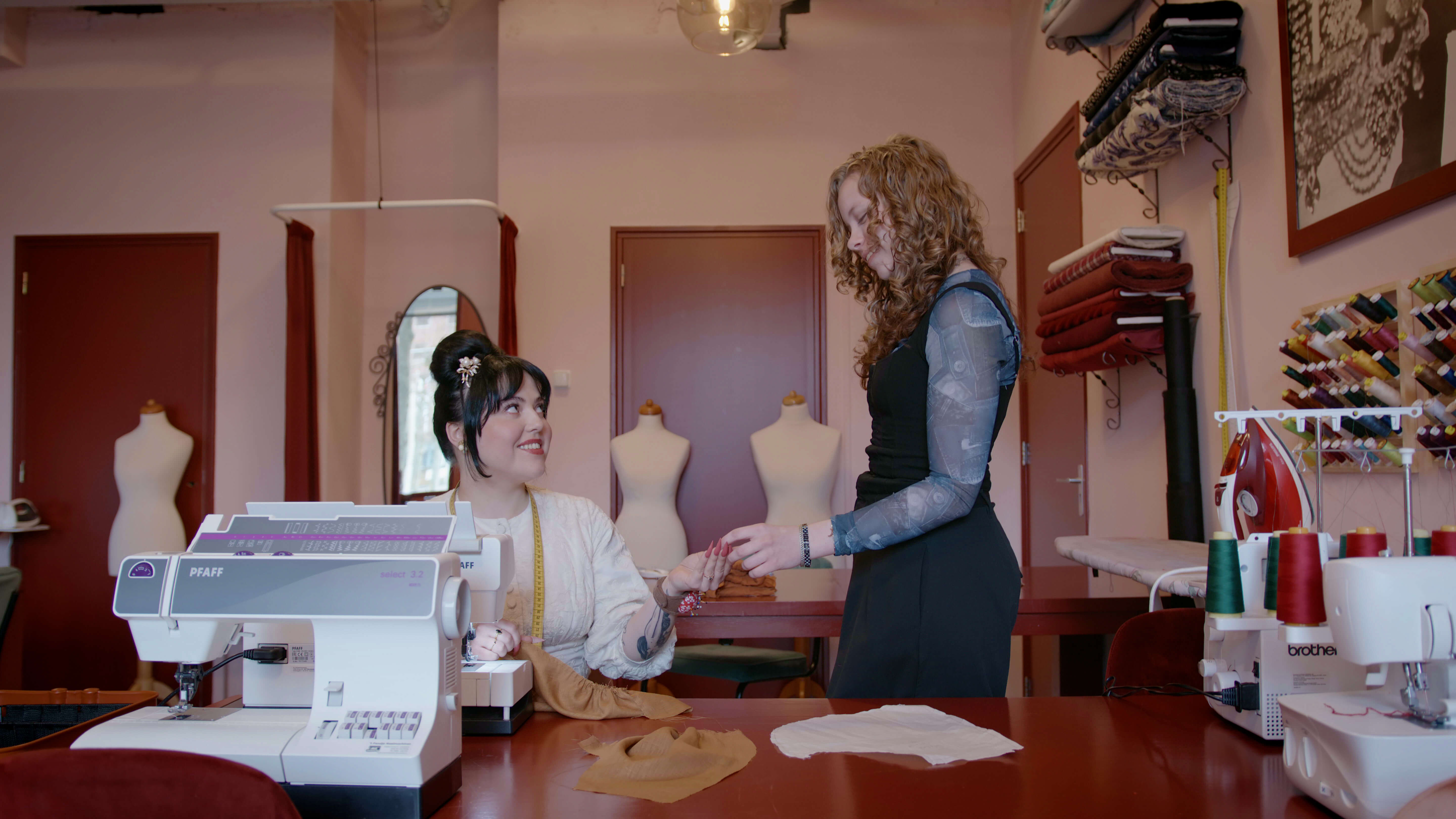 Twee vakspecialisten ondernemen samen in een werkruimte met naaimachines en stoffen