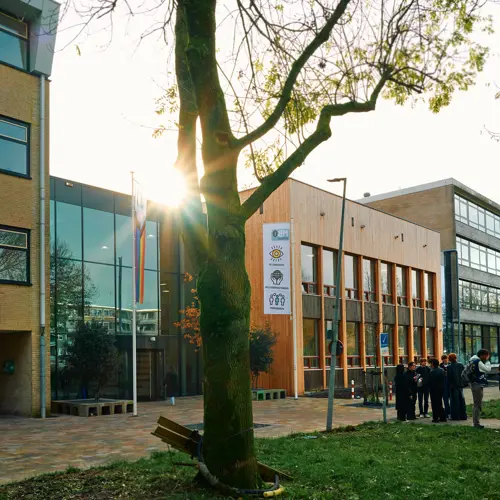 Gebouw van mbo Utrecht aan Australielaan 25 met groep studenten buiten op het grasveld