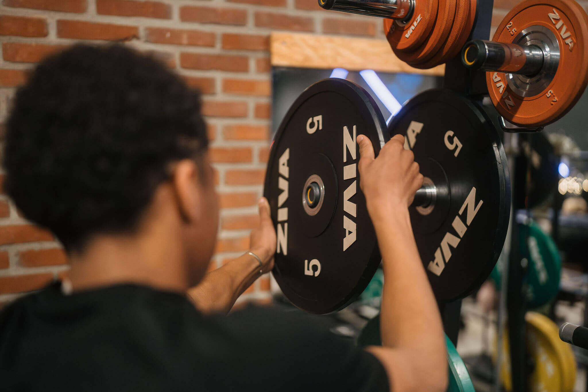 Leerling richt zich op gewichtstraining met halterschijven in een sportomgeving