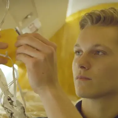 Technisch mbo-student controleert nauwkeurig elektrische verbindingen tijdens practicum