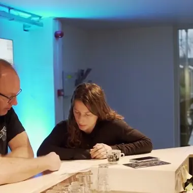 Technicus en leerling bespreken planning achter de schermen in een ruimte voor podiumtechniek en entertainment