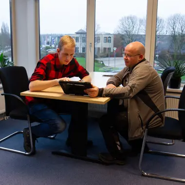 Twee personen overleggen aan tafel over groenprojecten en toekomstmogelijkheden in de buitenruimte