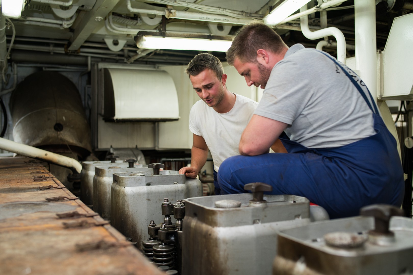 Twee leerlingen voeren onderhoud uit aan een scheepswerktuig tijdens de opleiding Schipper-machinist.