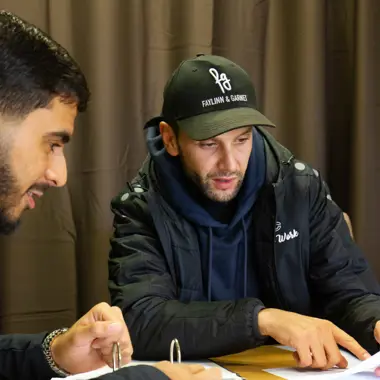 Twee studenten bekijken samen documenten om zich voor te bereiden op een praktijkopdracht in de welzijnssector.