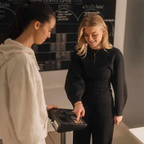 Twee studenten voeren een opdracht uit met een apparaat, gericht op voeding en leefstijladvies.