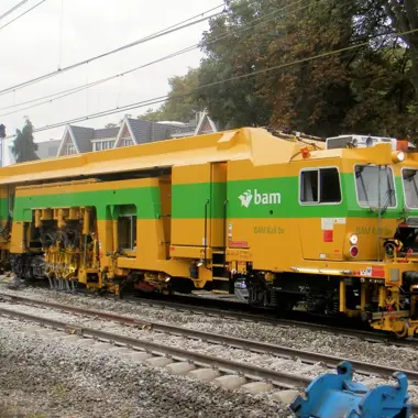 Spoorinfrastructuurmachine van BAM in actie voor onderhoud aan het spoor in stedelijk gebied