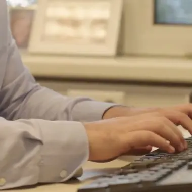 Medewerker voert administratieve werkzaamheden uit op toetsenbord aan bureau met telefoon