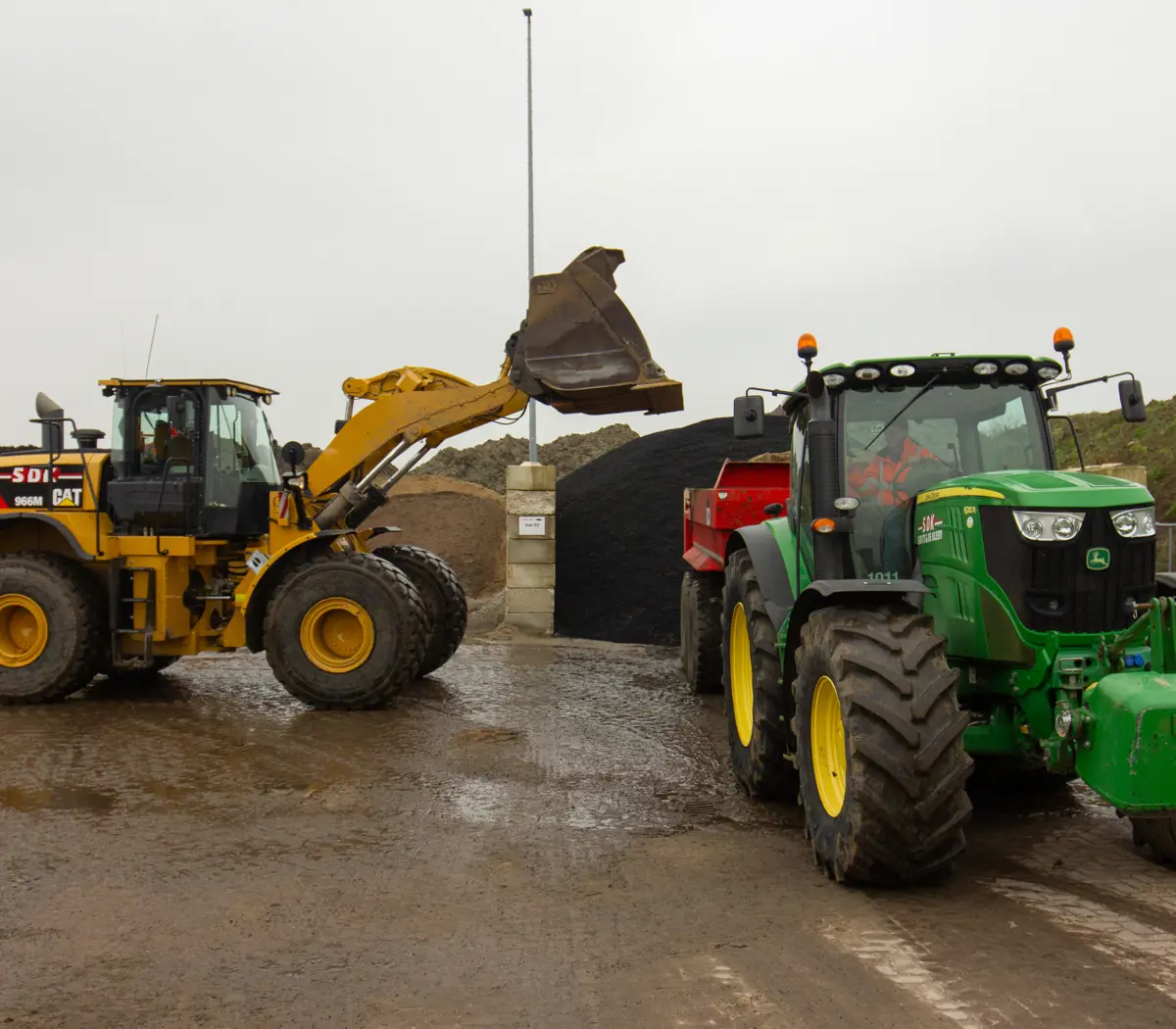 Medewerker groene infra bedient grote machines bij grondwerk in een buitengebied.