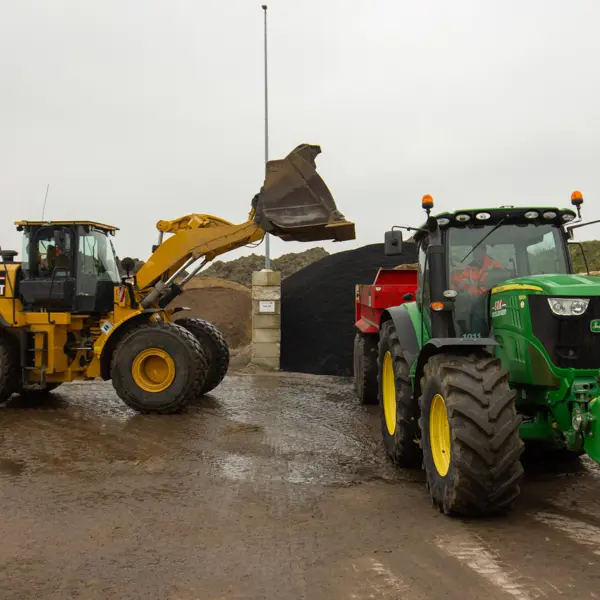 Medewerker groene infra bedient grote machines bij grondwerk in een buitengebied.