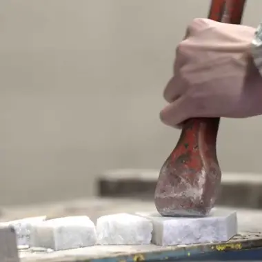 Hand bedient een beitel om een bouwmateriaal te bewerken tijdens een gespecialiseerde aanneming