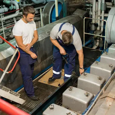 Twee mbo-studenten maritieme techniek inspecteren en onderhouden motoronderdelen aan boord van een schip.