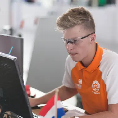 Student werkt geconcentreerd aan technische systemen via computer in een praktijkgericht leeromgeving