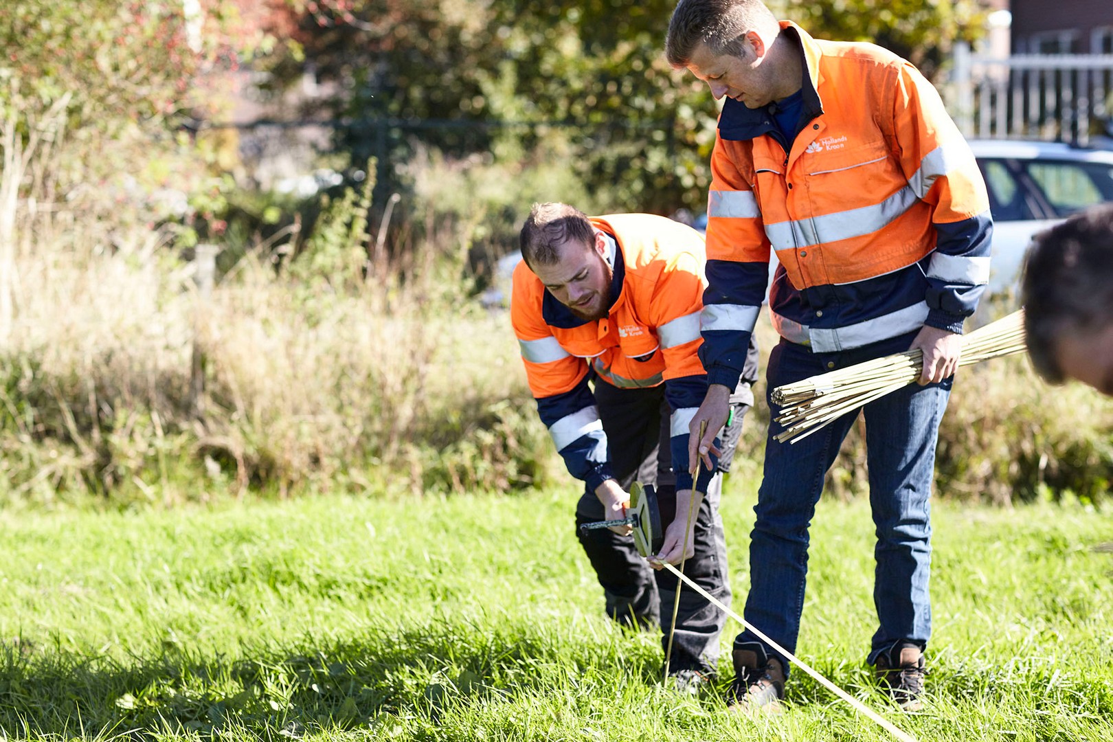 Medewerkers natuur, water en recreatie markeren werkgebied in groene buitenruimte tijdens praktijkopdracht