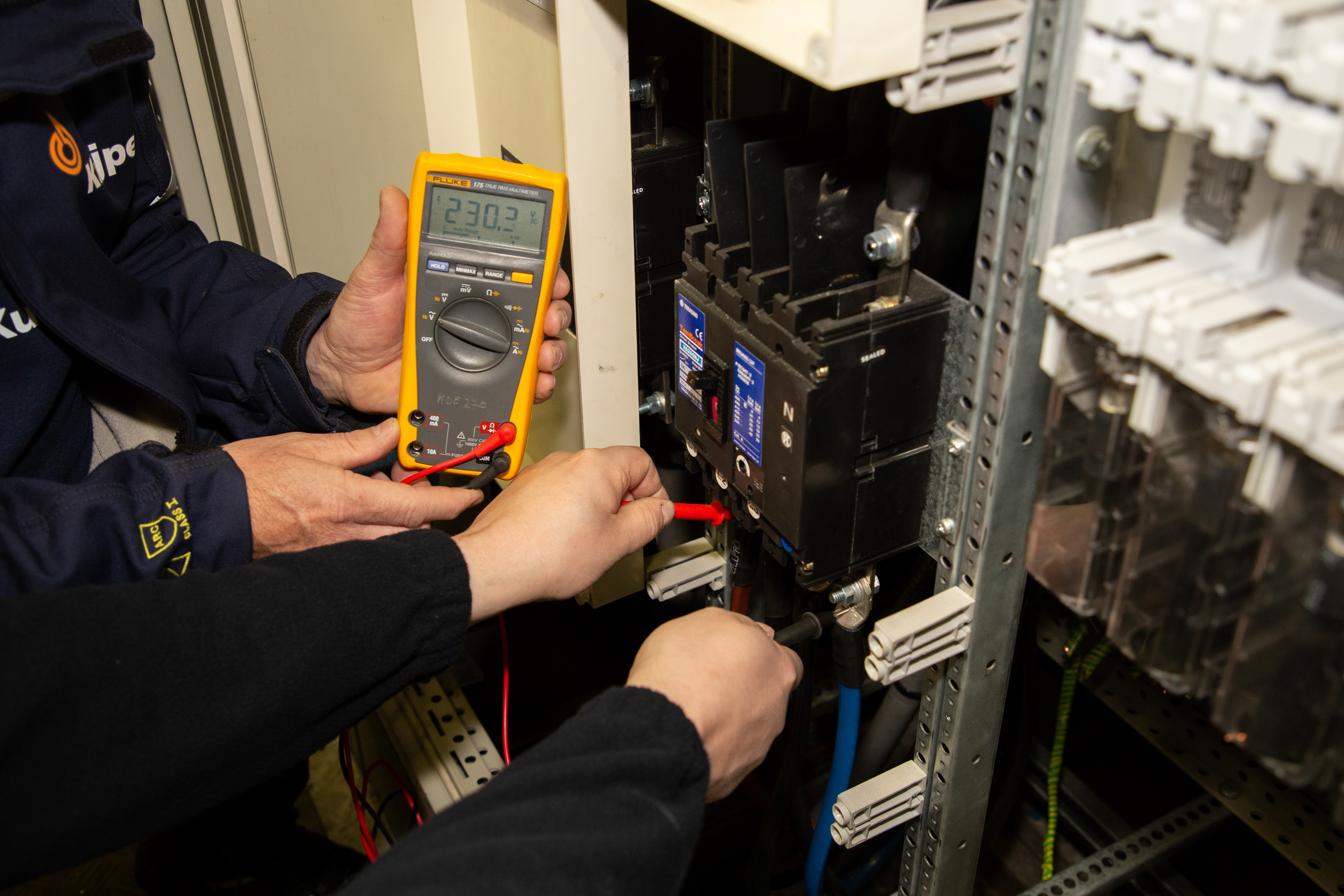 Technicus controleert elektrotechnische installatie met meetinstrument in gebouwde omgeving