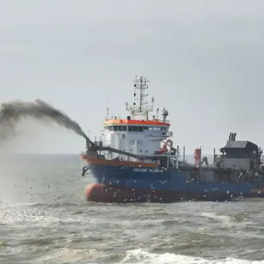 Werkschip op zee dat zand of slib inwater verplaatst, met focus op maritieme techniek en onderhoud.