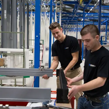 Medewerkers aan het werk met houtbewerking en montage in een productieomgeving