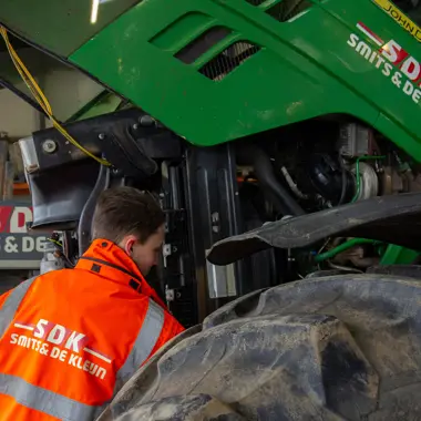 Leerling werkt aan onderhoud van landbouwmachine in een werkplaats voor groene beroepen