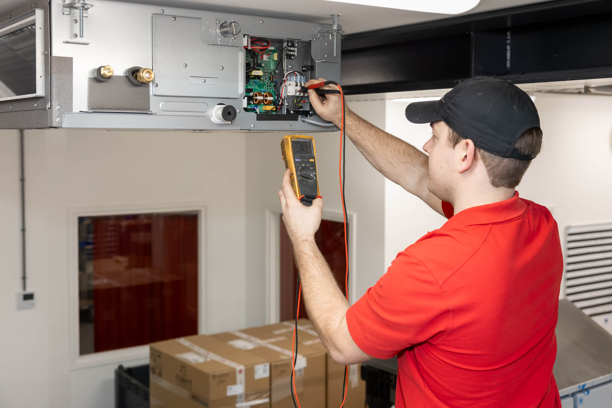 Technicus meet elektrische componenten in een ventilatiesysteem tijdens technisch onderhoud