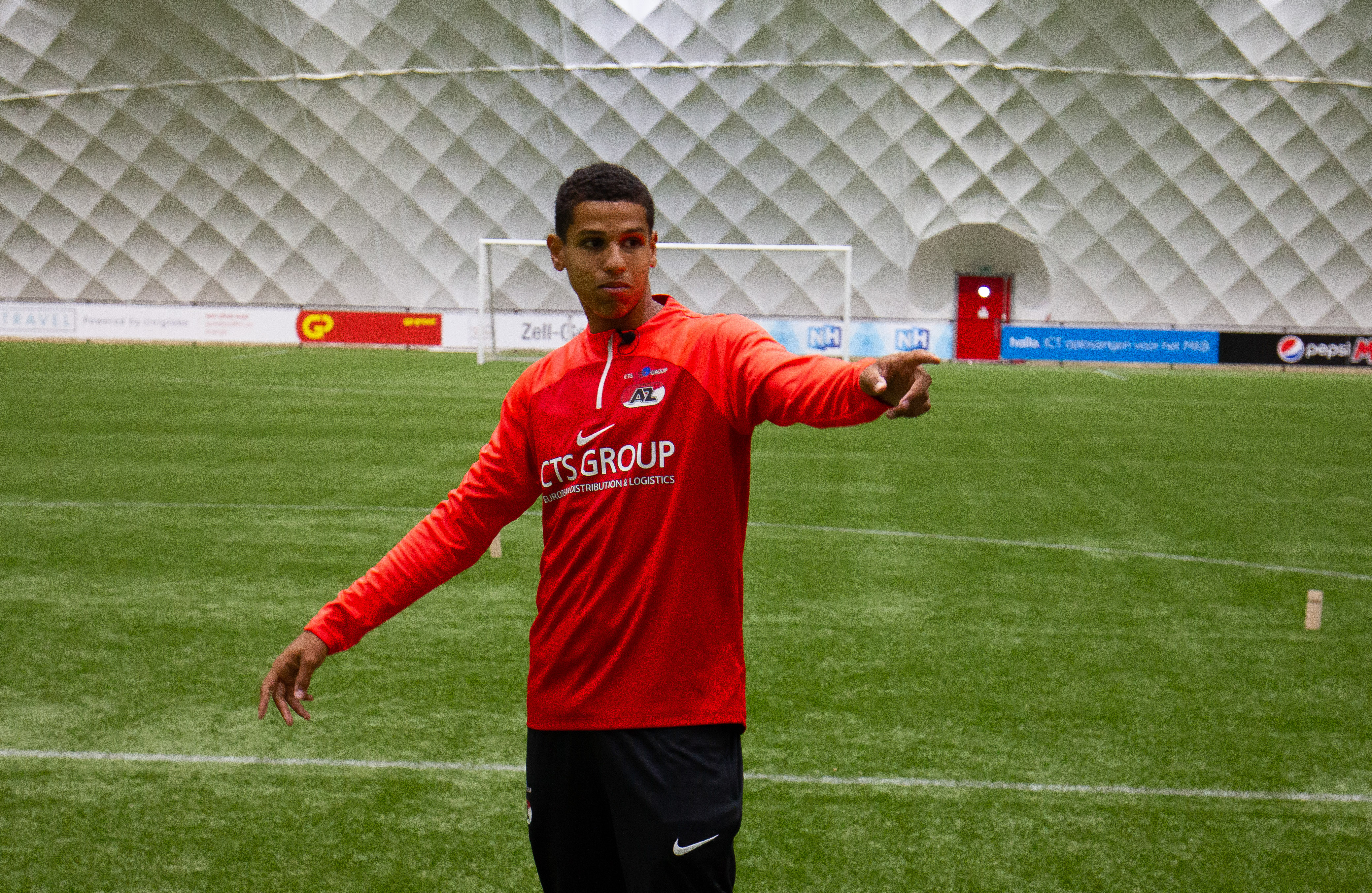 Sportbegeleider geeft instructies tijdens indoor training op voetbalveld
