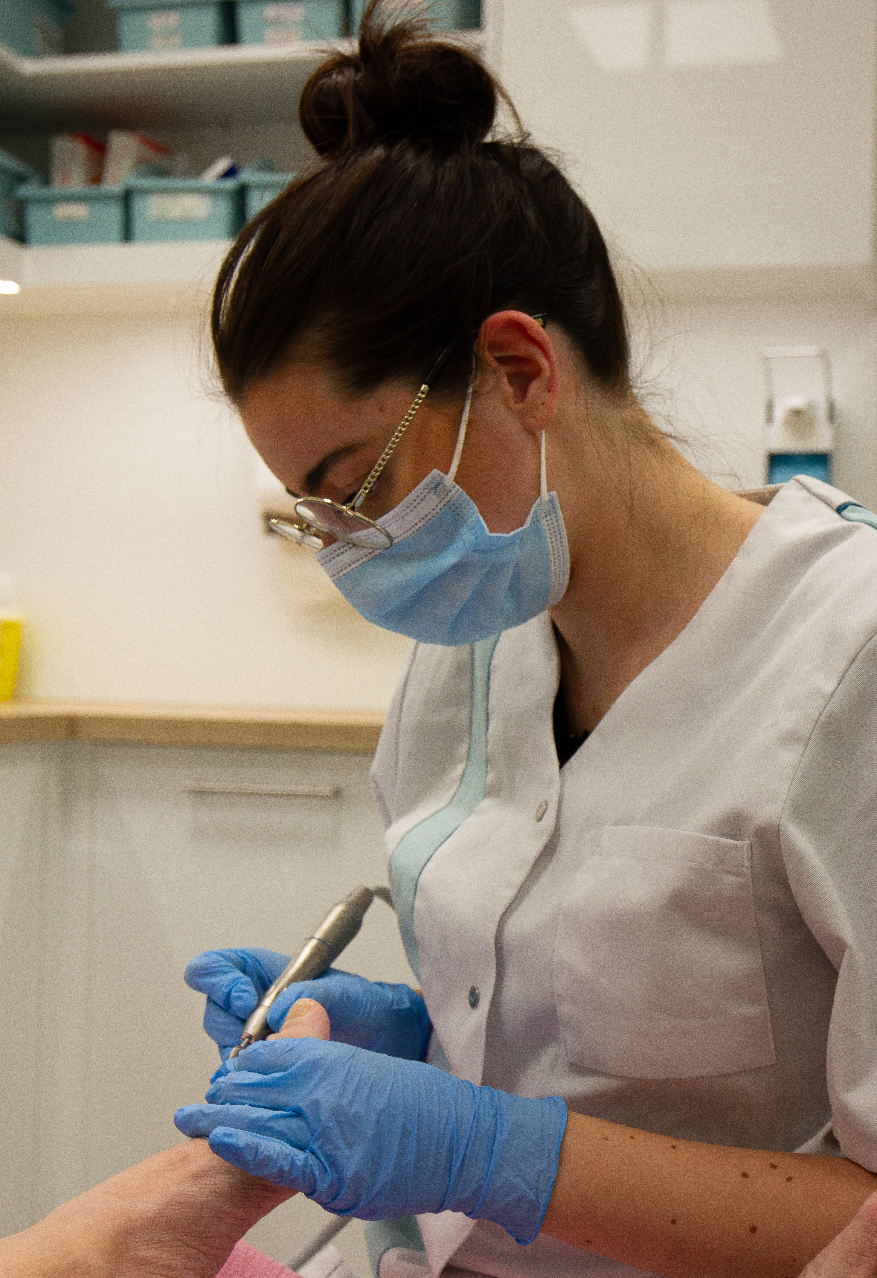 Medisch pedicure behandelt voet met apparaat in een zorgpraktijk, gericht op professionele voetverzorging.