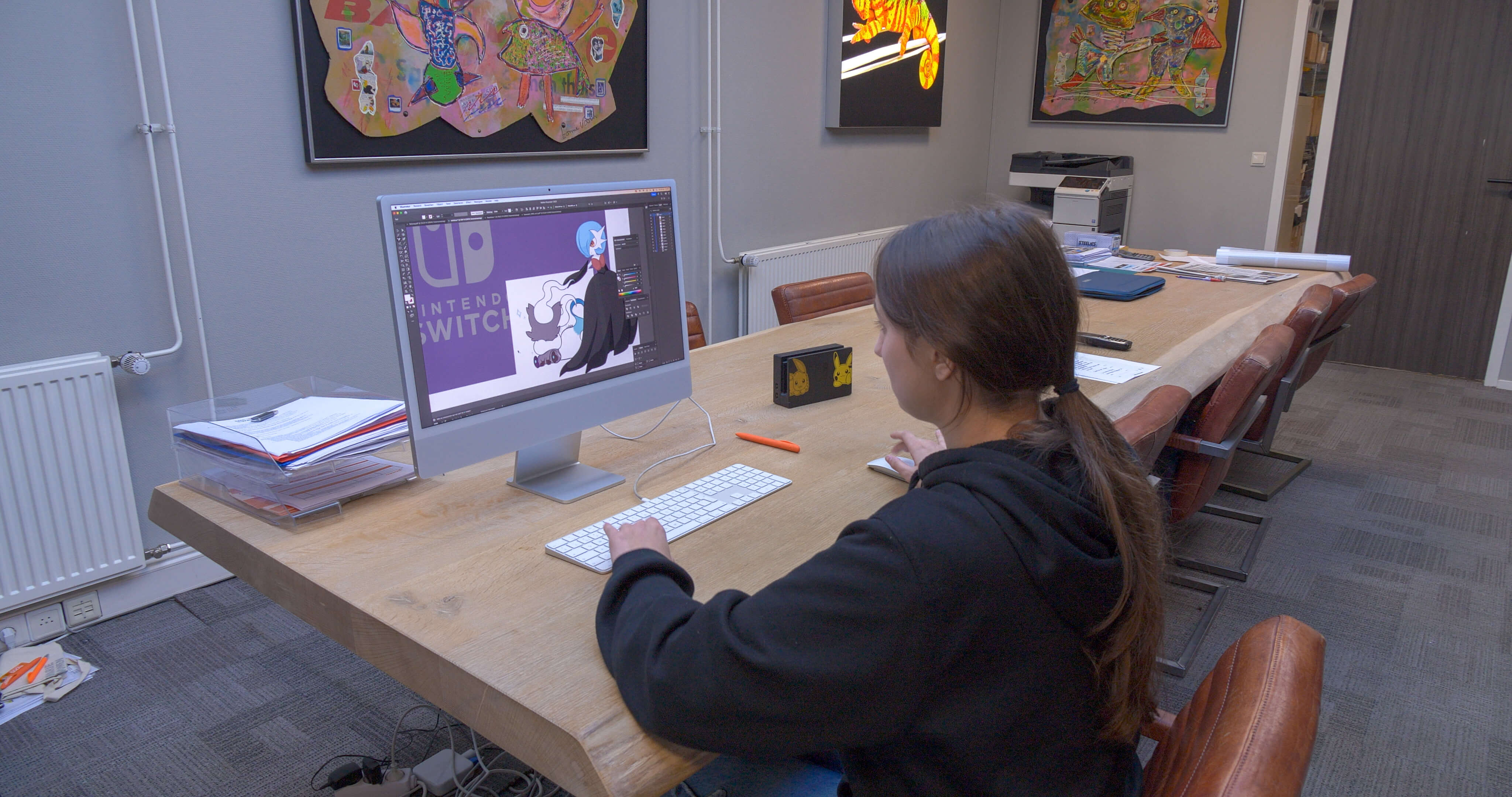 Leerling werkt geconcentreerd aan een computerproject in een creatieve klasomgeving.