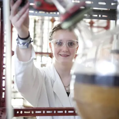 Student werkt nauwkeurig met apparatuur in een laboratorium binnen de procestechniek.