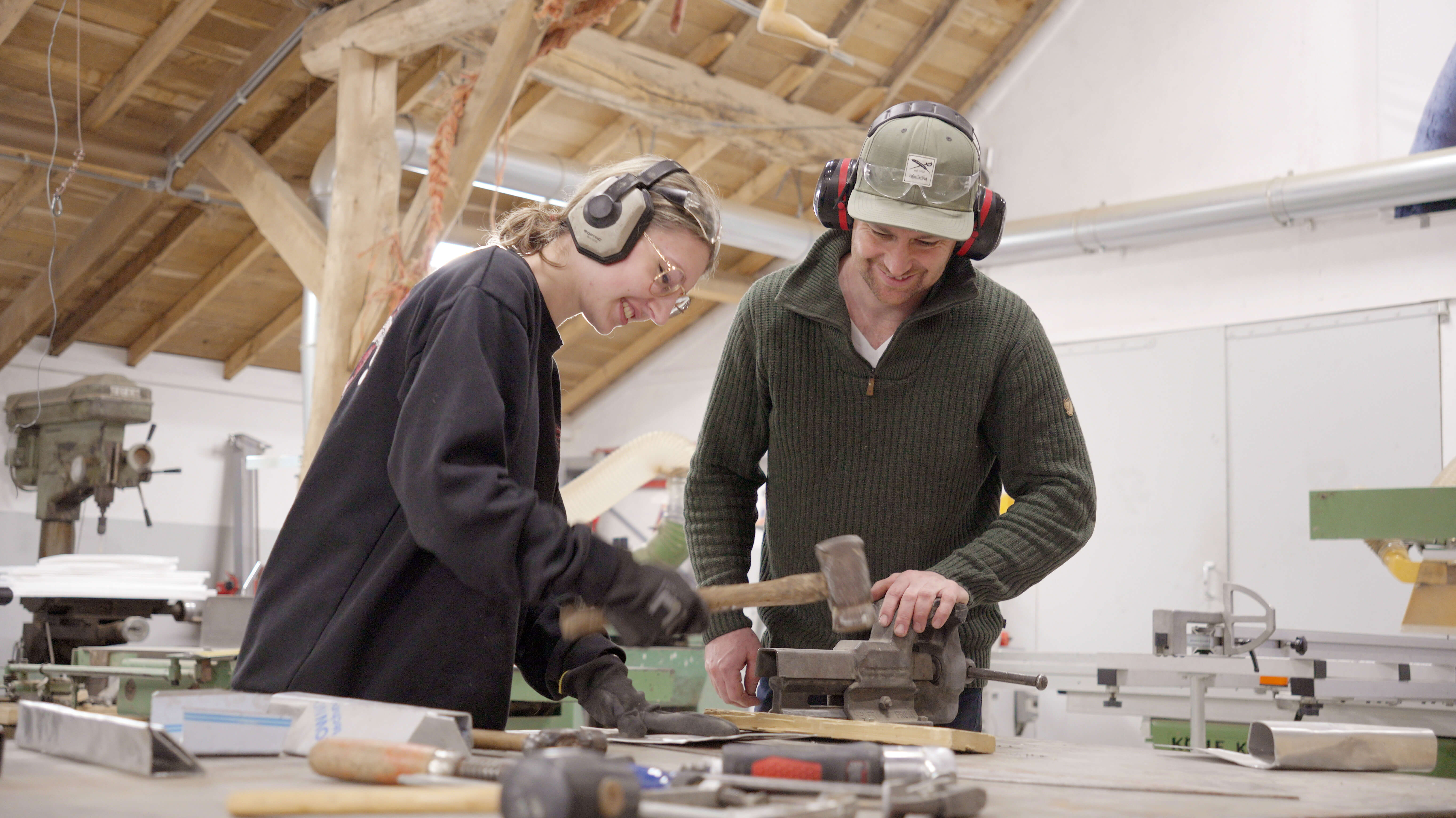 Student ruimtelijk vormgeven werkt samen met instructeur aan houtbewerking in werkplaats