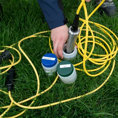 Medewerker verricht buitenshuis metingen in de bodem voor milieukundige analyse