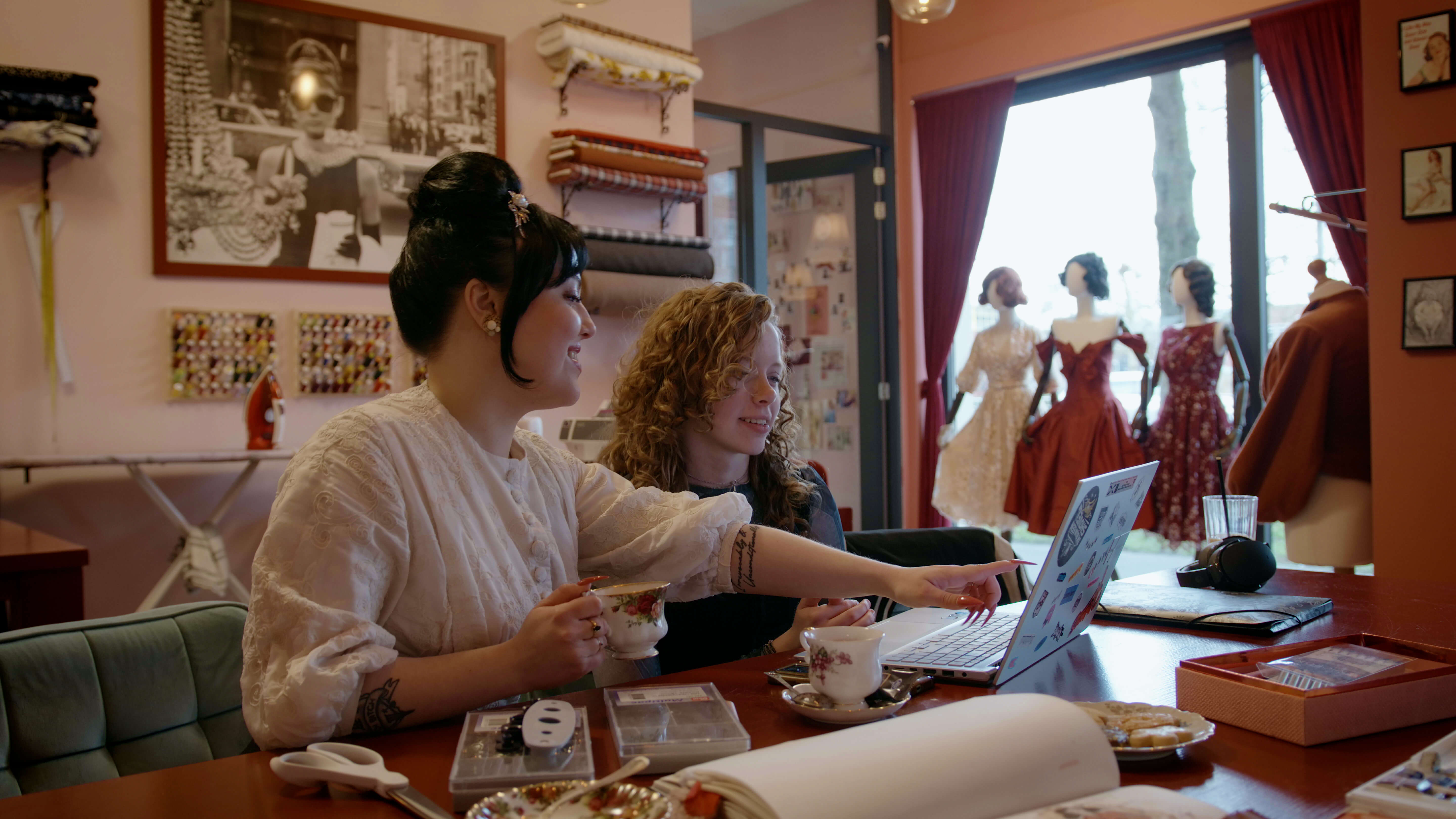 Twee studenten bespreken een ondernemingsplan tijdens een gesprek met laptop in een creatieve werkruimte
