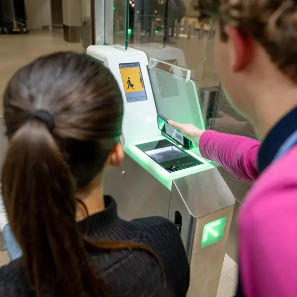 Studenten gebruiken een zelfservicebalie voor het inchecken bij de luchthaven als onderdeel van de luchtvaartdienstverlening.